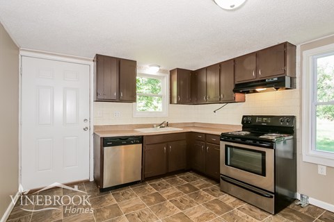 a kitchen with stainless steel appliances and brown cabinets
