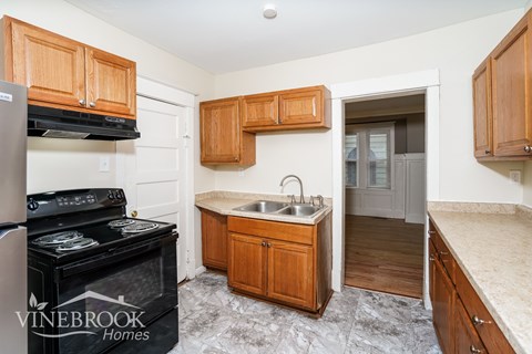 A kitchen with wooden cabinets and a black stove top oven.