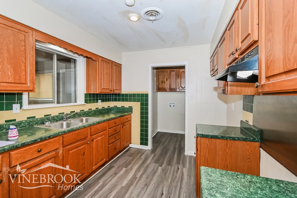 A kitchen with wooden cabinets and green countertops.