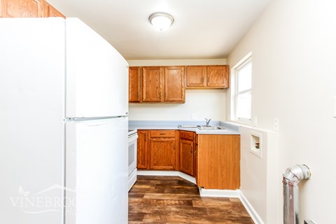 A kitchen with wooden cabinets and a white refrigerator.