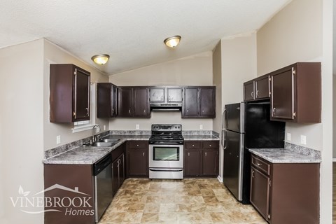 A kitchen with brown cabinets and appliances.