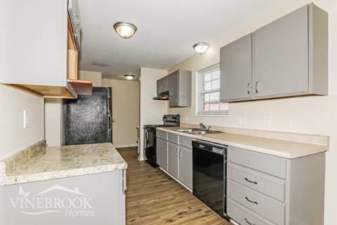A kitchen with a granite counter top and a Vinebrook Homes logo.