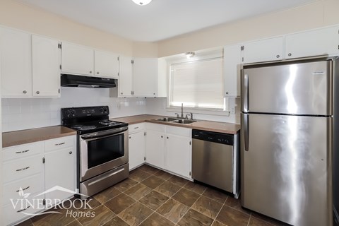 A kitchen with white cabinets and stainless steel appliances.