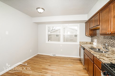 A kitchen with wooden cabinets and a granite countertop.