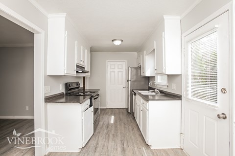 A kitchen with white cabinets and appliances is shown.