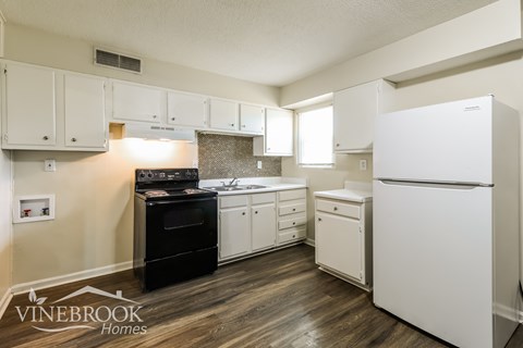 A kitchen with white appliances and cabinets.