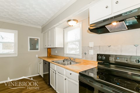 A kitchen with a stove top oven and a sink.