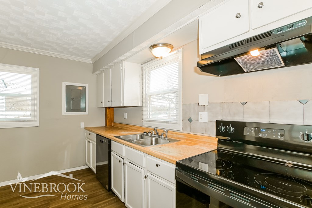 A kitchen with a stove top oven and a sink.