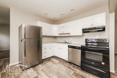 A modern kitchen with stainless steel appliances and white cabinets.