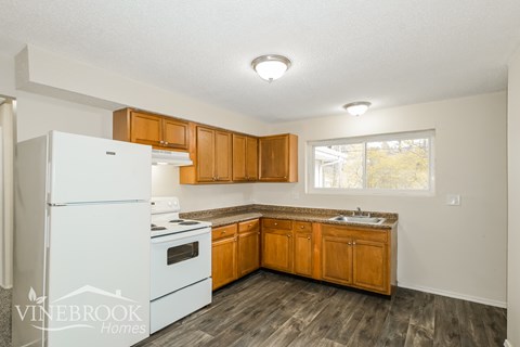A kitchen with wooden cabinets and a white fridge.