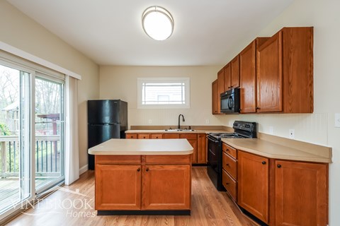 A kitchen with wooden cabinets and a white countertop.