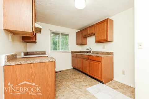 A kitchen with wooden cabinets and a granite countertop.
