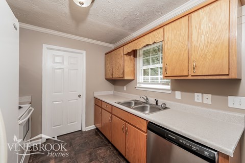 A kitchen with wooden cabinets and a white countertop.