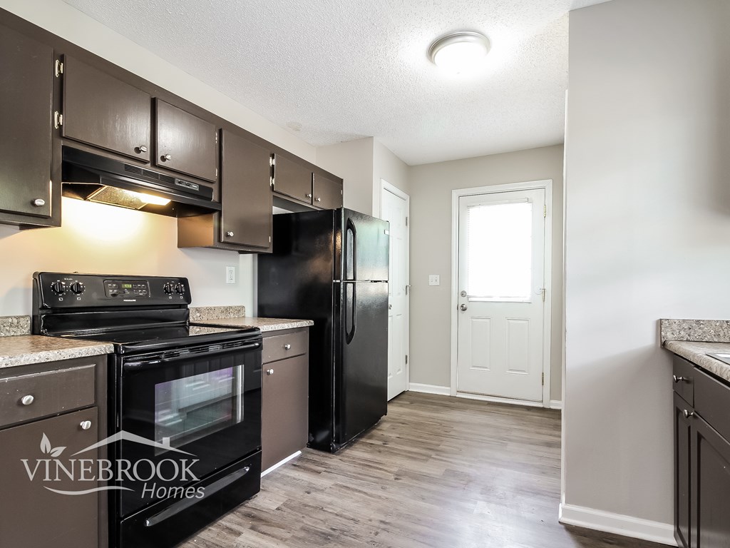 A kitchen with a black refrigerator and stove.