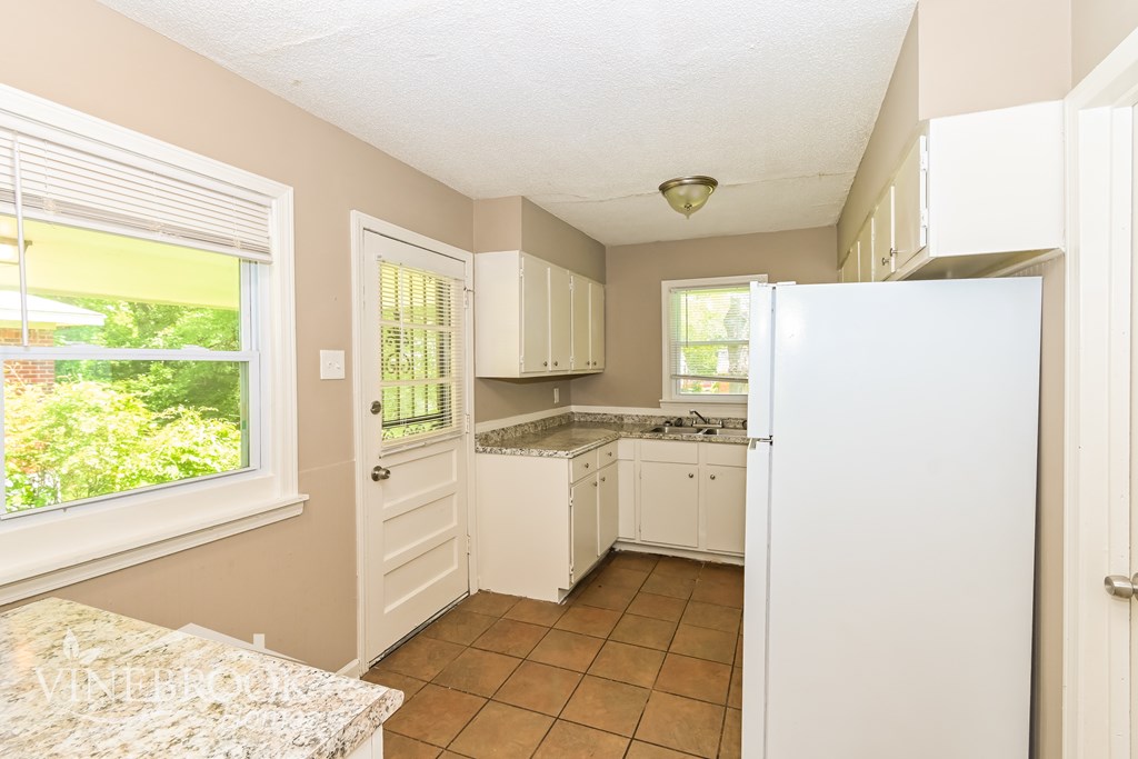 A kitchen with white appliances and cabinets.