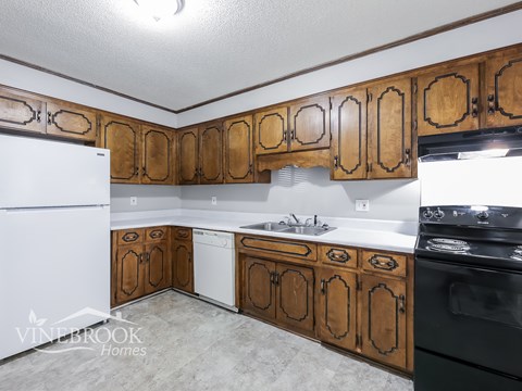 A kitchen with wooden cabinets and a white fridge.