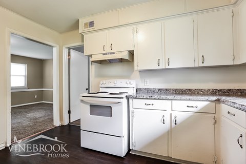 A kitchen with white appliances and cabinets.
