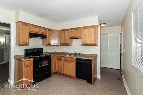 A kitchen with wooden cabinets and black appliances.