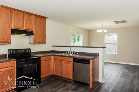 A kitchen with wooden cabinets and a black stove top oven.