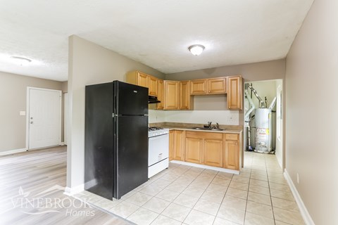 A kitchen with black appliances and wooden cabinets.