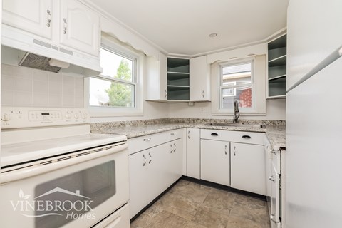A kitchen with white appliances and cabinets.