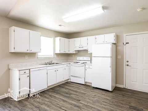 A kitchen with white appliances and cabinets.
