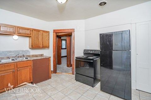 A kitchen with a sink, stove, and refrigerator.