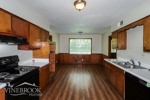 A kitchen with wooden cabinets and a black stove top oven.