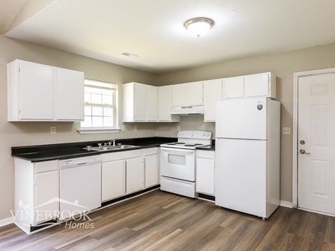 A kitchen with white cabinets and appliances.
