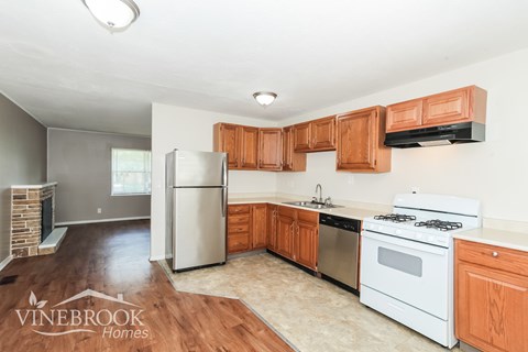 A kitchen with wooden cabinets and a white stove top oven.