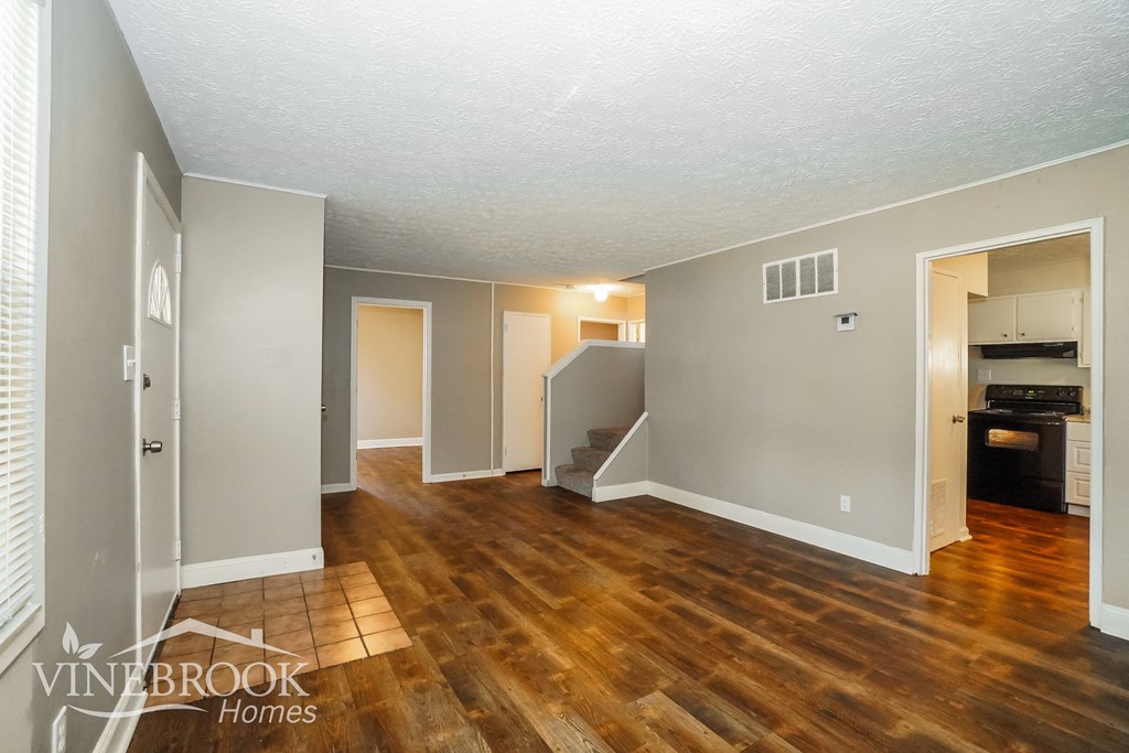the living room and dining room of an open floor plan with wood flooring