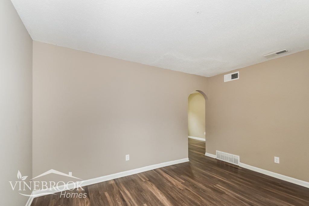 A room with wooden flooring and a wall-mounted light fixture.