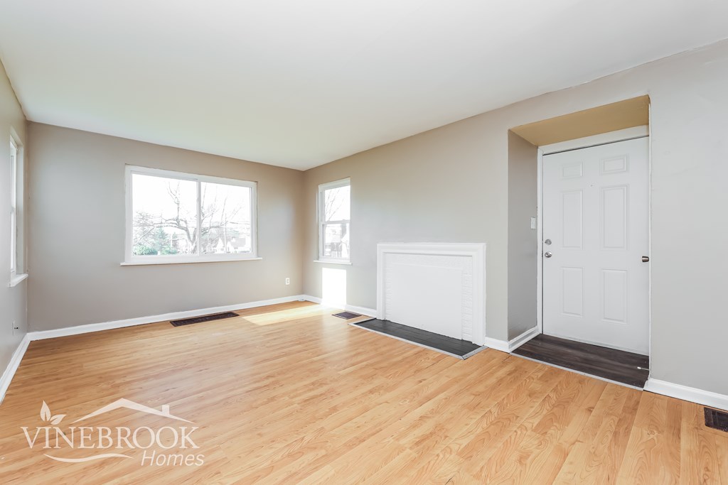 A room with wooden floors and two white doors.