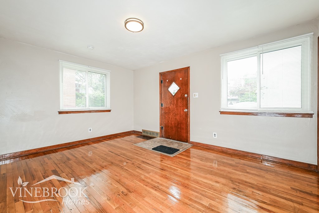 A room with a wooden floor and a door in the middle.