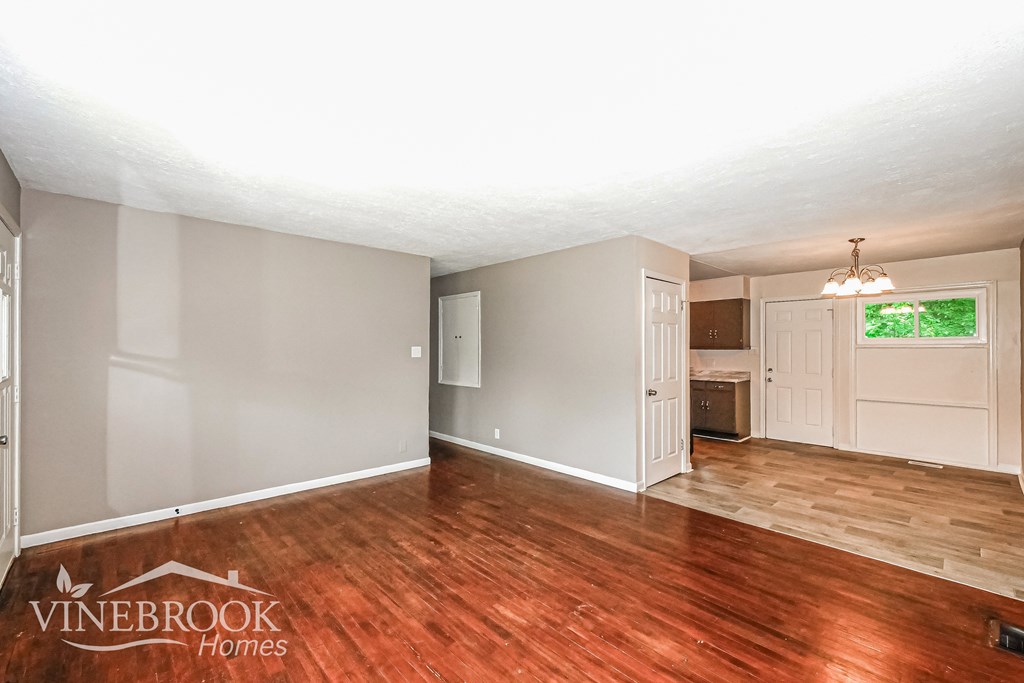 A room with wood flooring and a Vinebrook Homes logo.