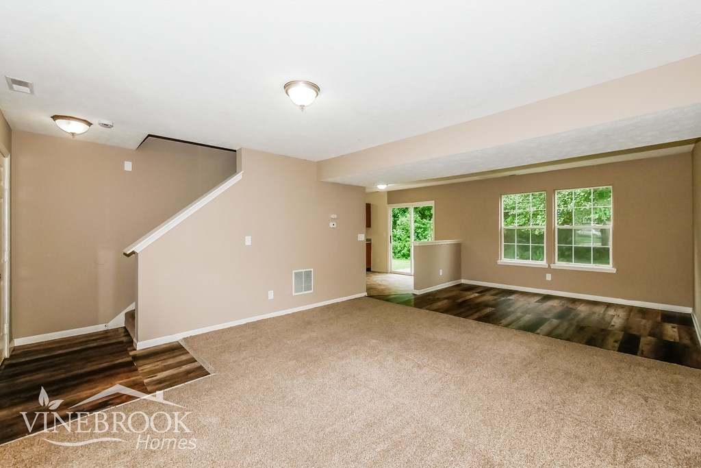 A spacious room with a staircase and a window.