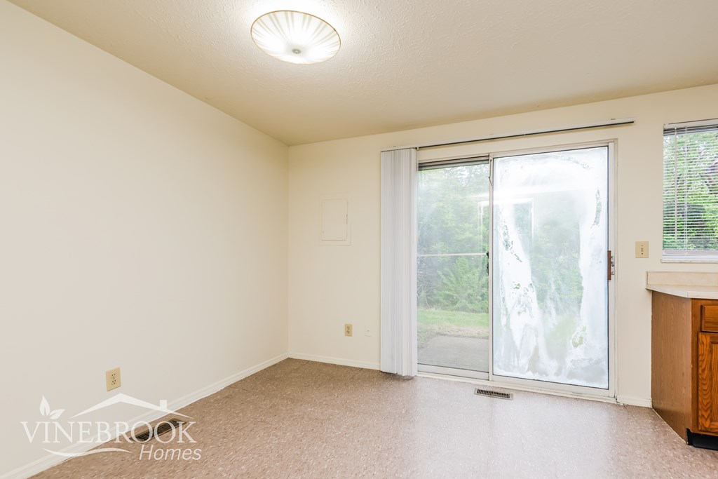A room with a sliding glass door leading to a backyard.