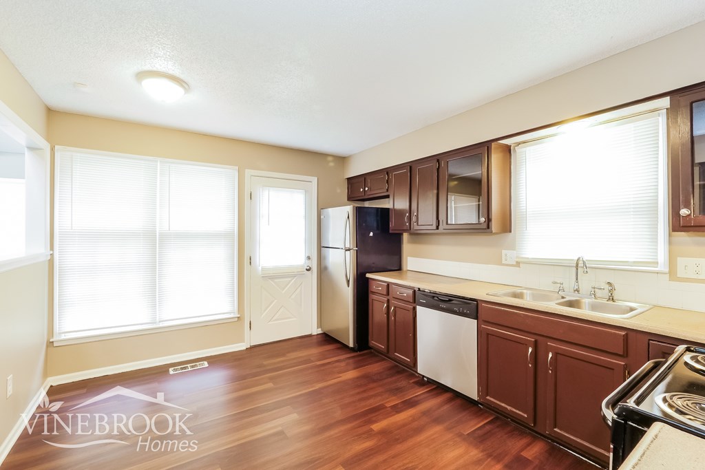 A kitchen with brown cabinets and a dishwasher.