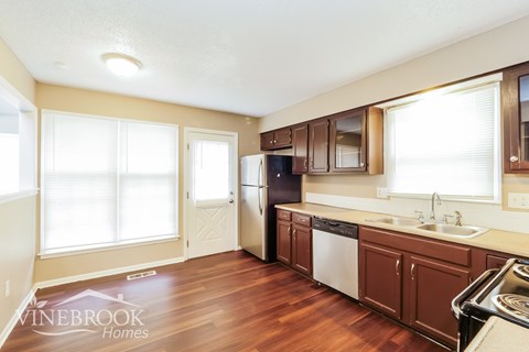 A kitchen with brown cabinets and a dishwasher.