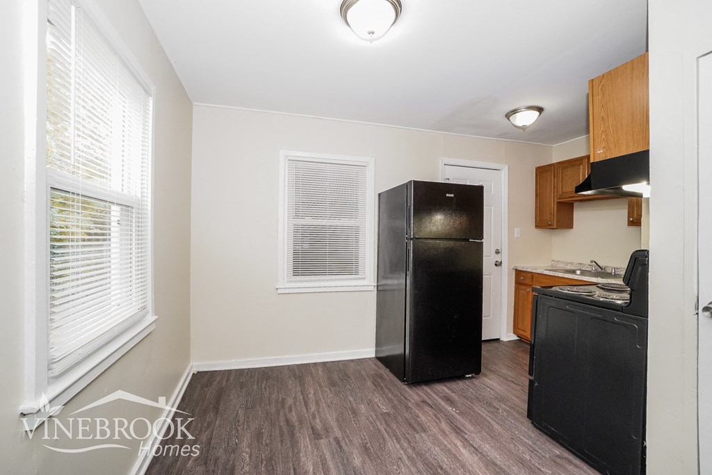 a kitchen with a refrigerator and a sink and a window