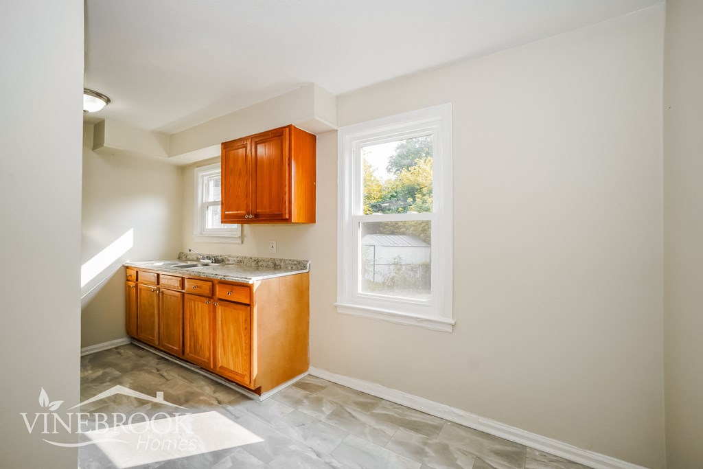 a small kitchen with wooden cabinets and a window