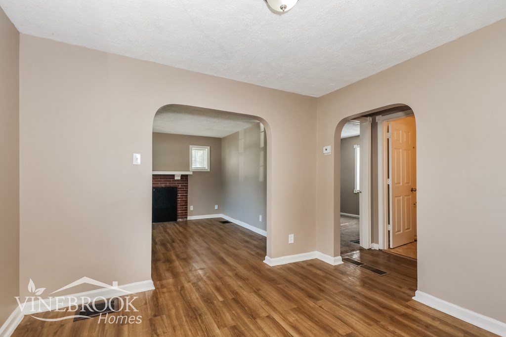 a living room and dining room with wood flooring and a fireplace