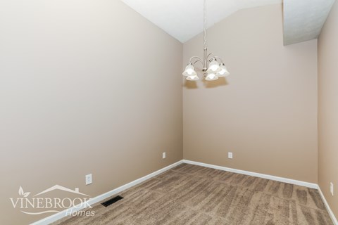 a living room with a carpet and a chandelier