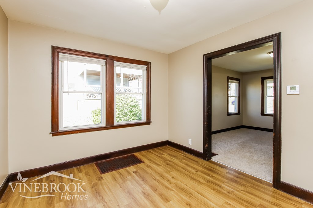 A room with a wooden floor and a large mirror on the wall.
