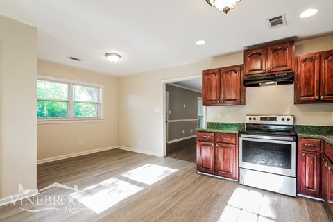 A kitchen with wooden cabinets and a stainless steel oven.