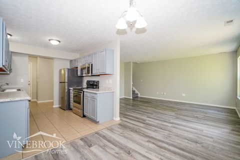 A kitchen with a refrigerator, oven, and microwave.