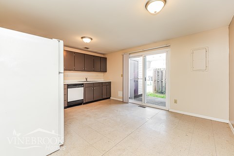 A kitchen with a white refrigerator and a tiled floor.