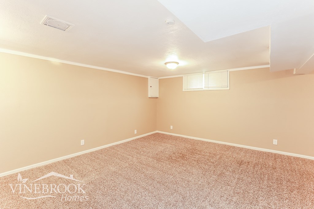 the upstairs bedroom has a carpeted floor and a window