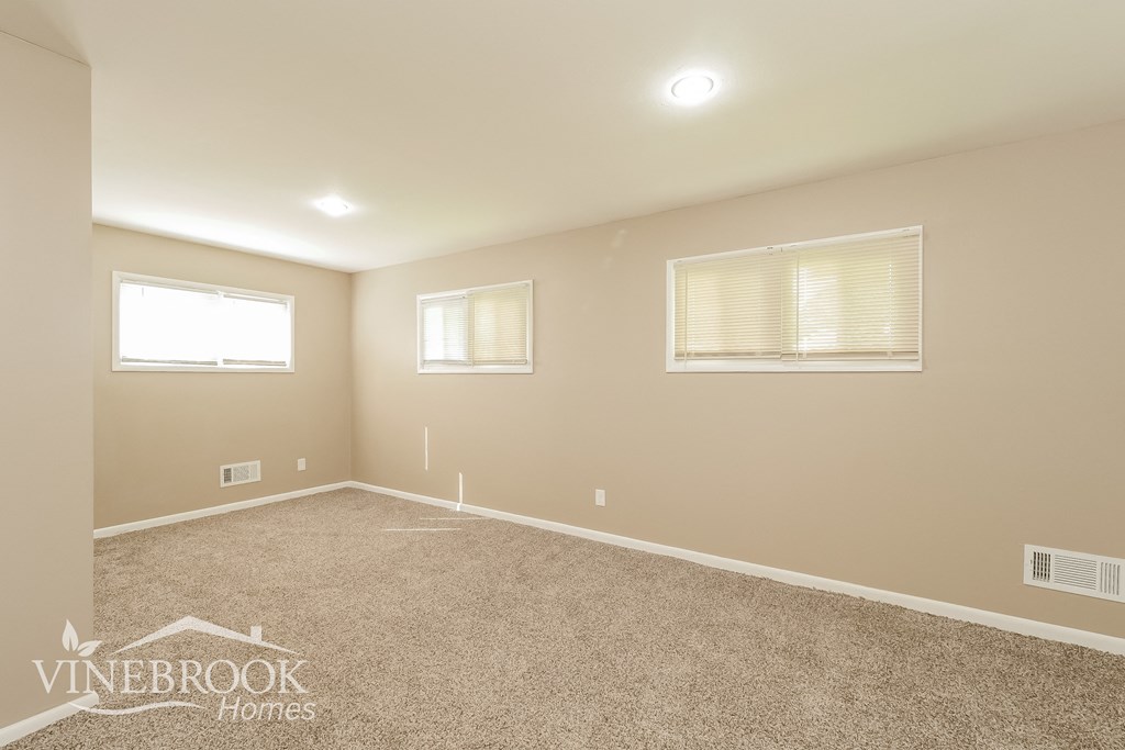 the upstairs bonus room has a carpeted floor and two windows