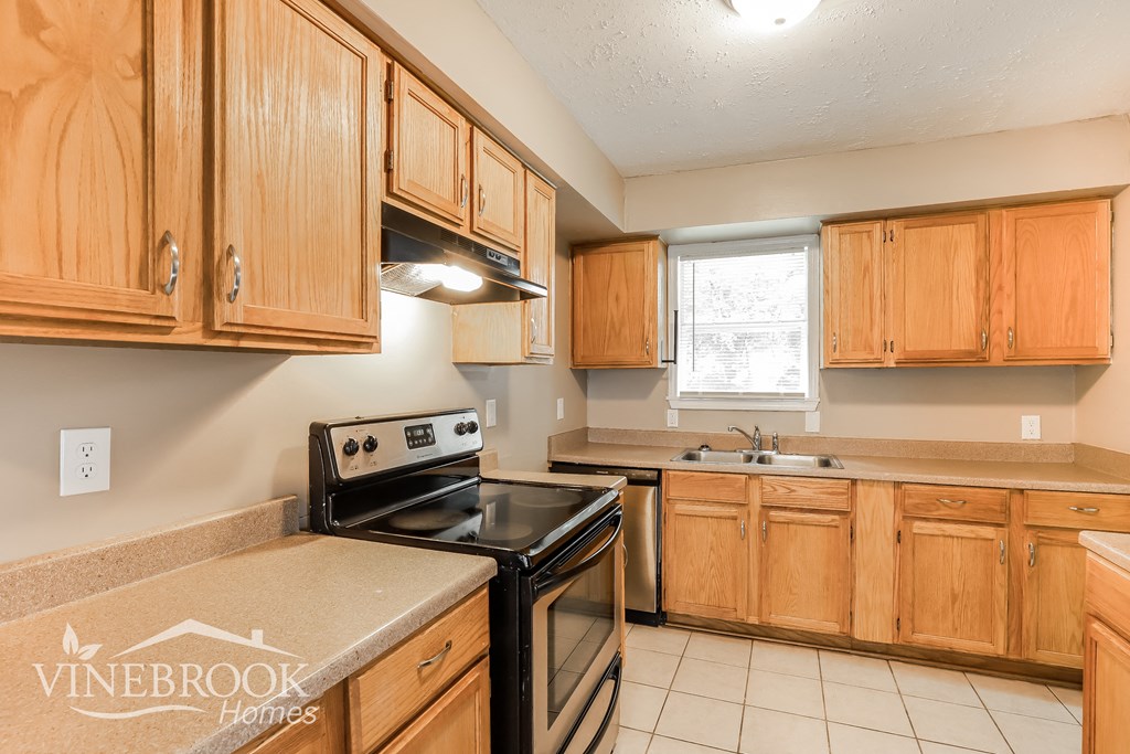 the kitchen is clean and ready to use with wood cabinets and black appliances
